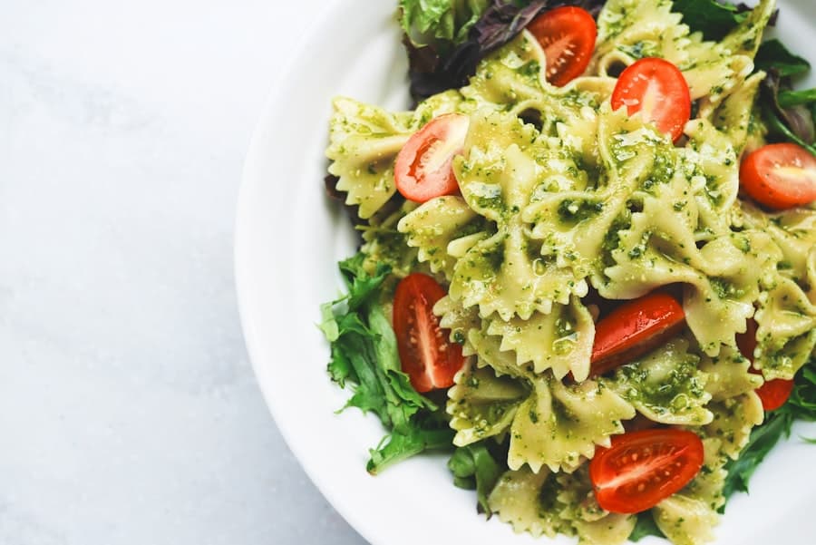 Pesto farfalle with cherry tomatoes in a white bowl